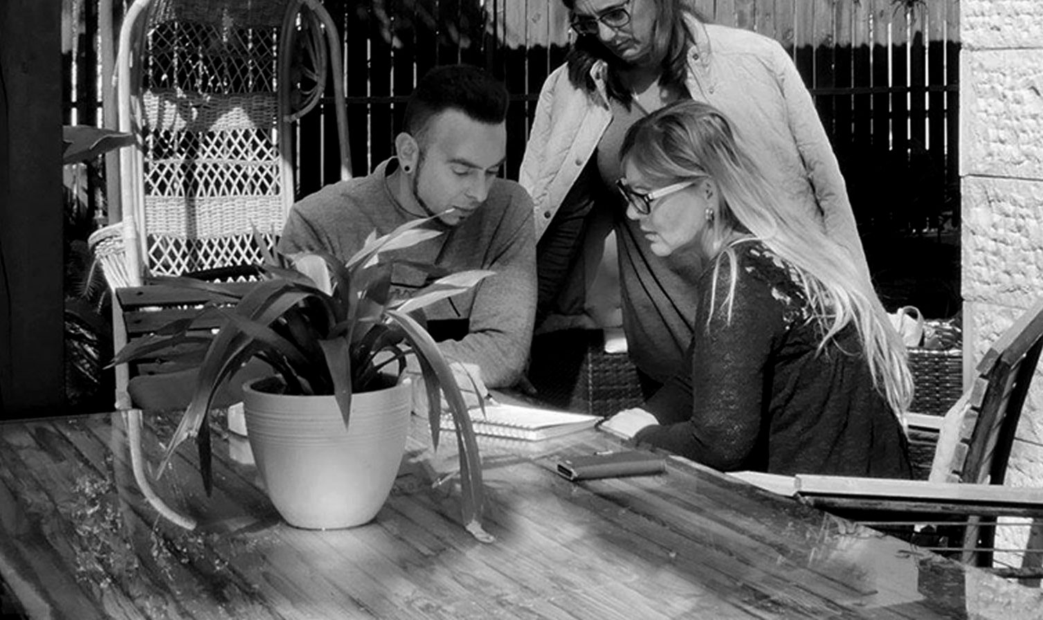 Interior Designer Yuri Nulman sitting with two clients in front of a desk and drafting