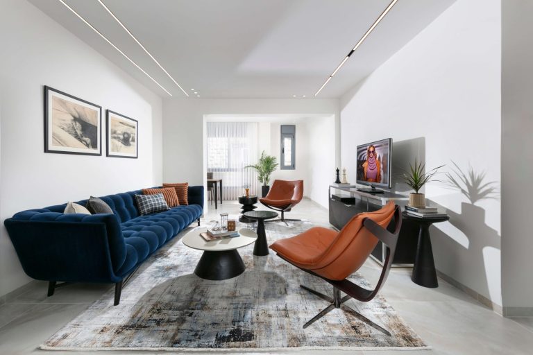 Living room space with a large Dark blue sofa facing two brown armchairs