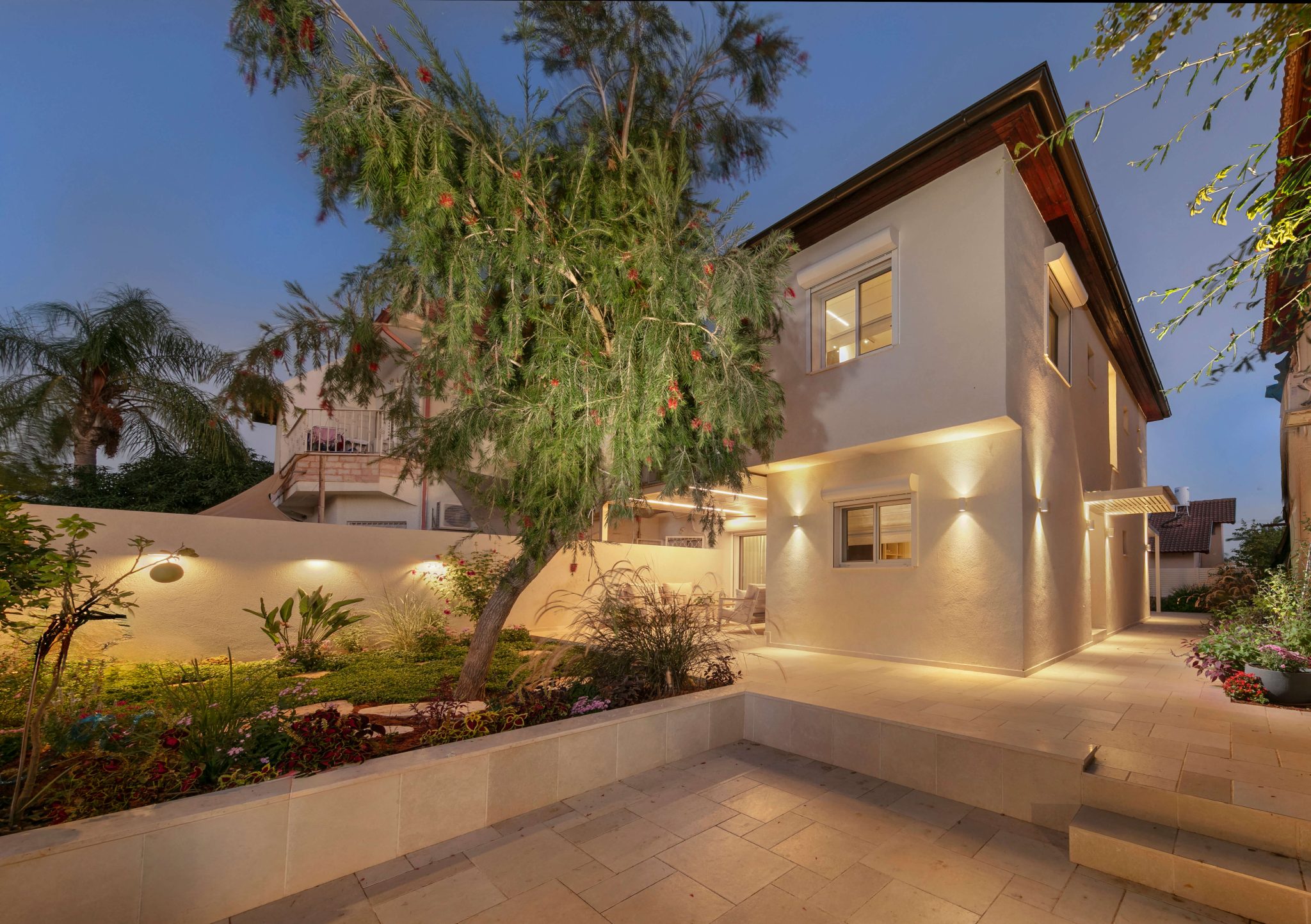 בית פרטי בכוכב יאיר בשעות הערב, מואר בתאורת אווירה המדגישה את החזיתות ואזורי הבית השונים